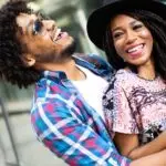 Happy young black couple hugging and laughing outdoors